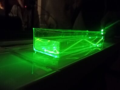 Réflexion totale subit par un laser vert dans de l'eau colorée